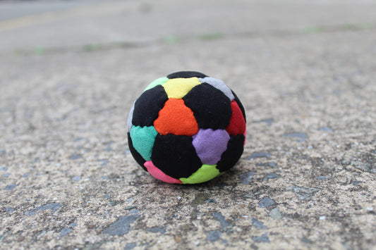 32 panel, hand stitched, synthetic suede juggling ball with a rubber and steel filling in Mixed colors including Black, Red, Orange, Yellow, Pink