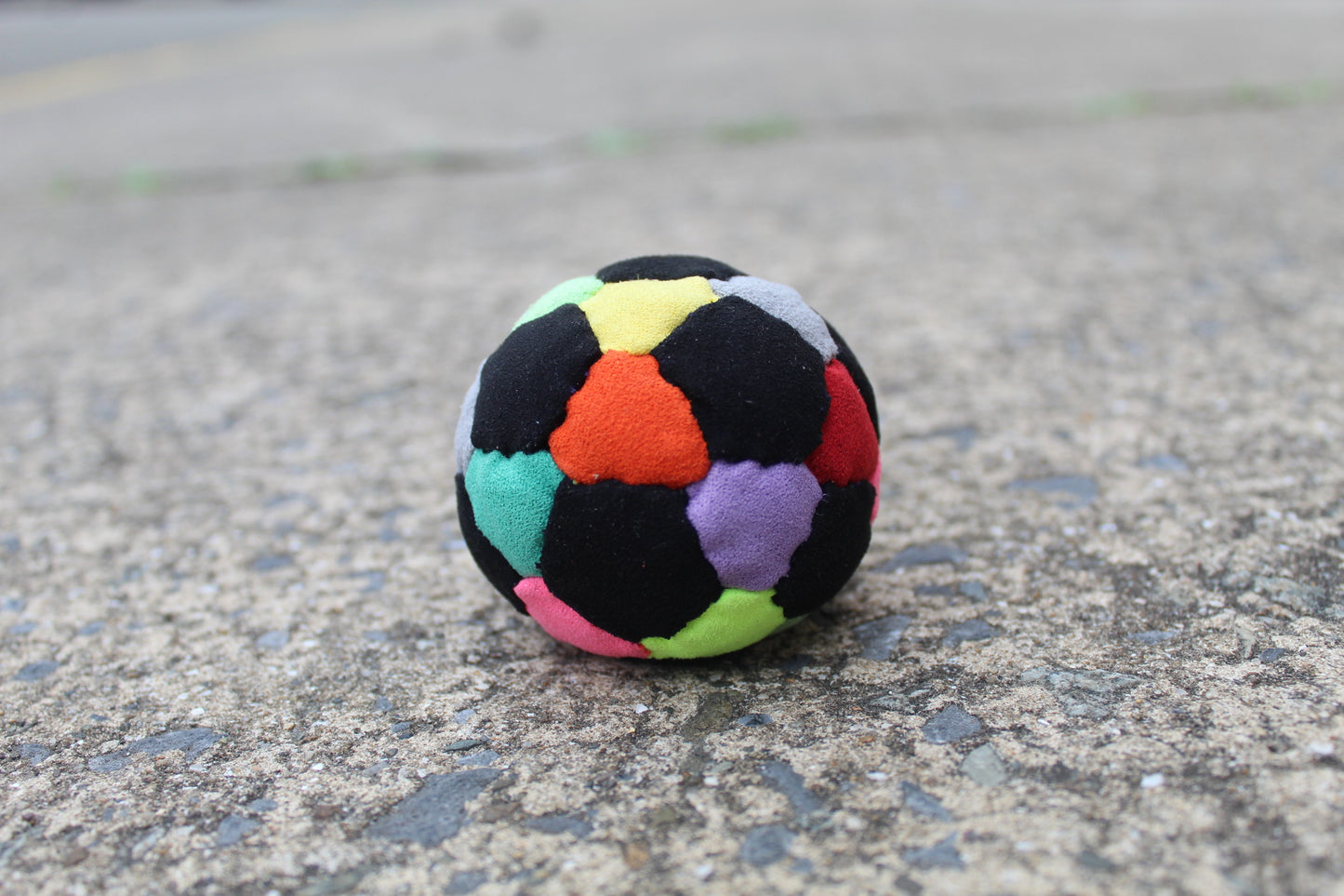32 panel, hand stitched, synthetic suede juggling ball with a rubber and steel filling in Mixed colors including Black, Red, Orange, Yellow, Pink