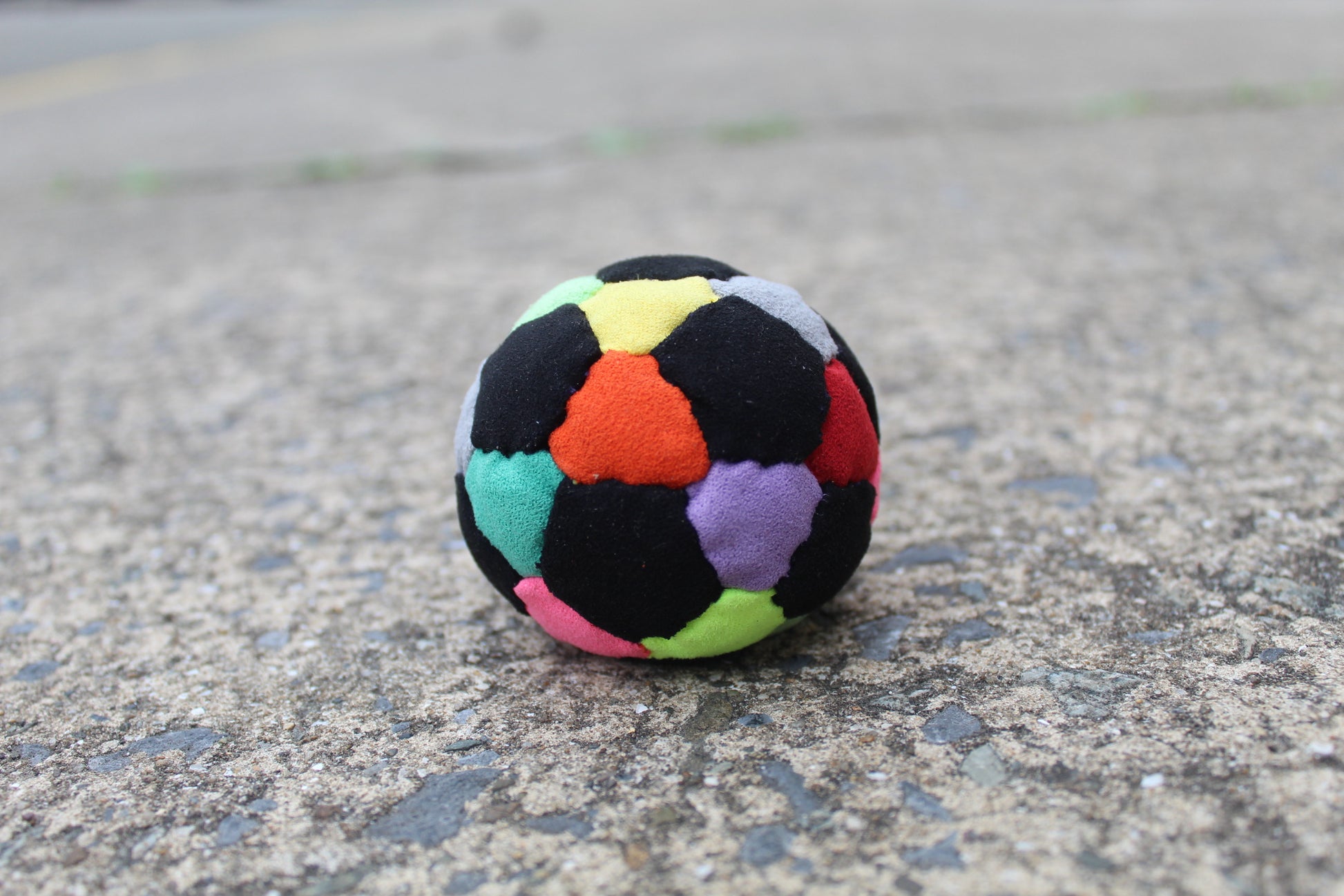 32 panel, hand stitched, synthetic suede juggling ball with a rubber and steel filling in Mixed colors including Black, Red, Orange, Yellow, Pink