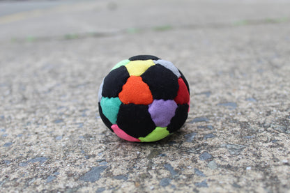 32 panel, hand stitched, synthetic suede juggling ball with a rubber and steel filling in Mixed colors including Black, Red, Orange, Yellow, Pink